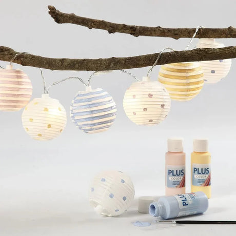 Akrylfärger - Tre färgflaskor i milda pastellnyanser på ett bord. - Tidformera