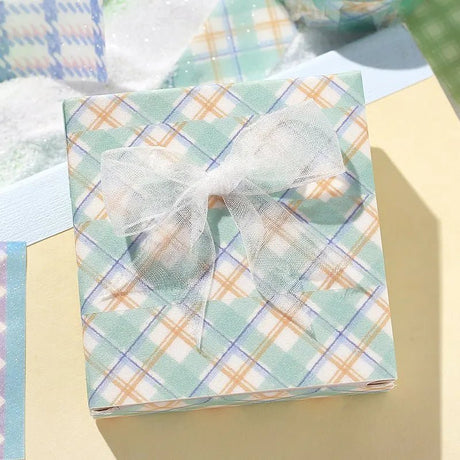 Mint - Ett paket inslaget med washi tape i mintfärg och orange rutigt mönster. - Tidformera