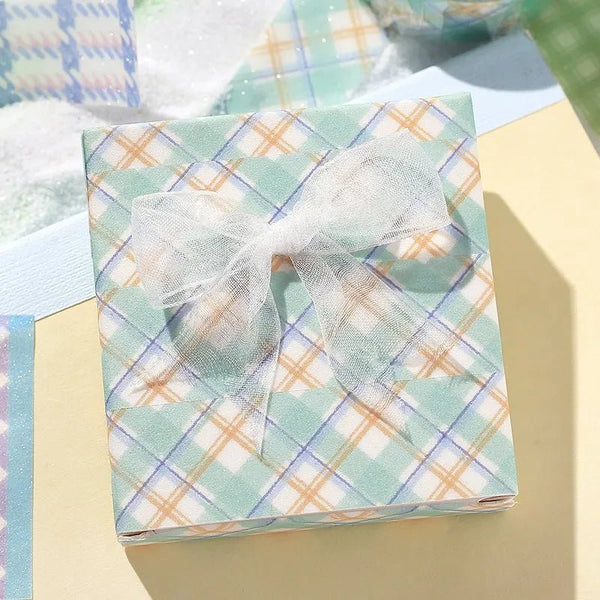 Mint - Ett paket inslaget med washi tape i mintfärg och orange rutigt mönster. - Tidformera