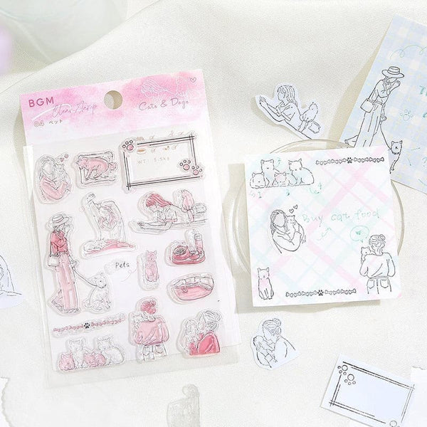 Förpackning med Clear stamps Holidays från BGM. Stämplar ligger på ett bord med papper som har stämplade motiv. - Tidformera