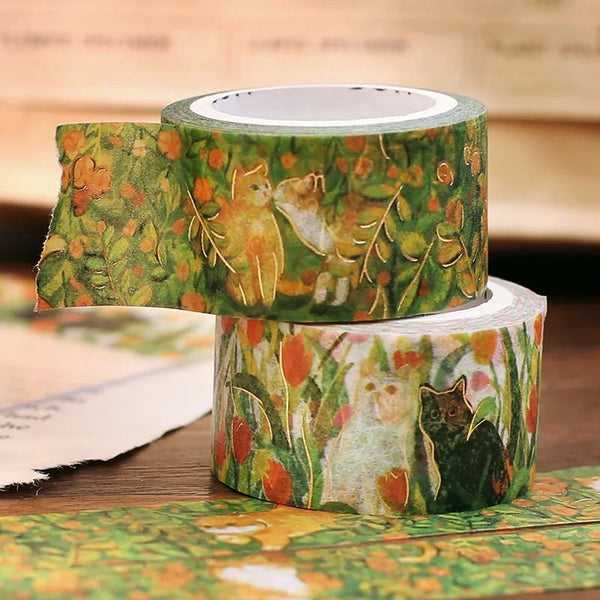 Washi tape - Flower and kitty från BGM. Två rullar washi tape ligger på en hög. Motiv med katter som nosar, omgivna av gräs och blommor. Tidformera
