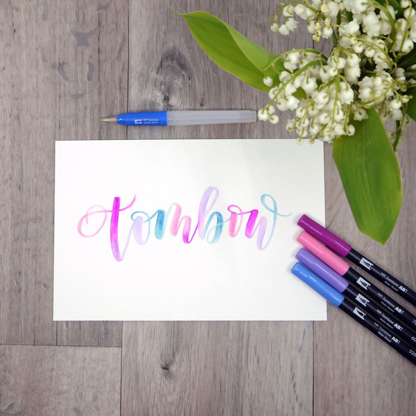 ABT dual brush pen ligger uppradade bredvid texten Tombow. Tidformera - Tidformera