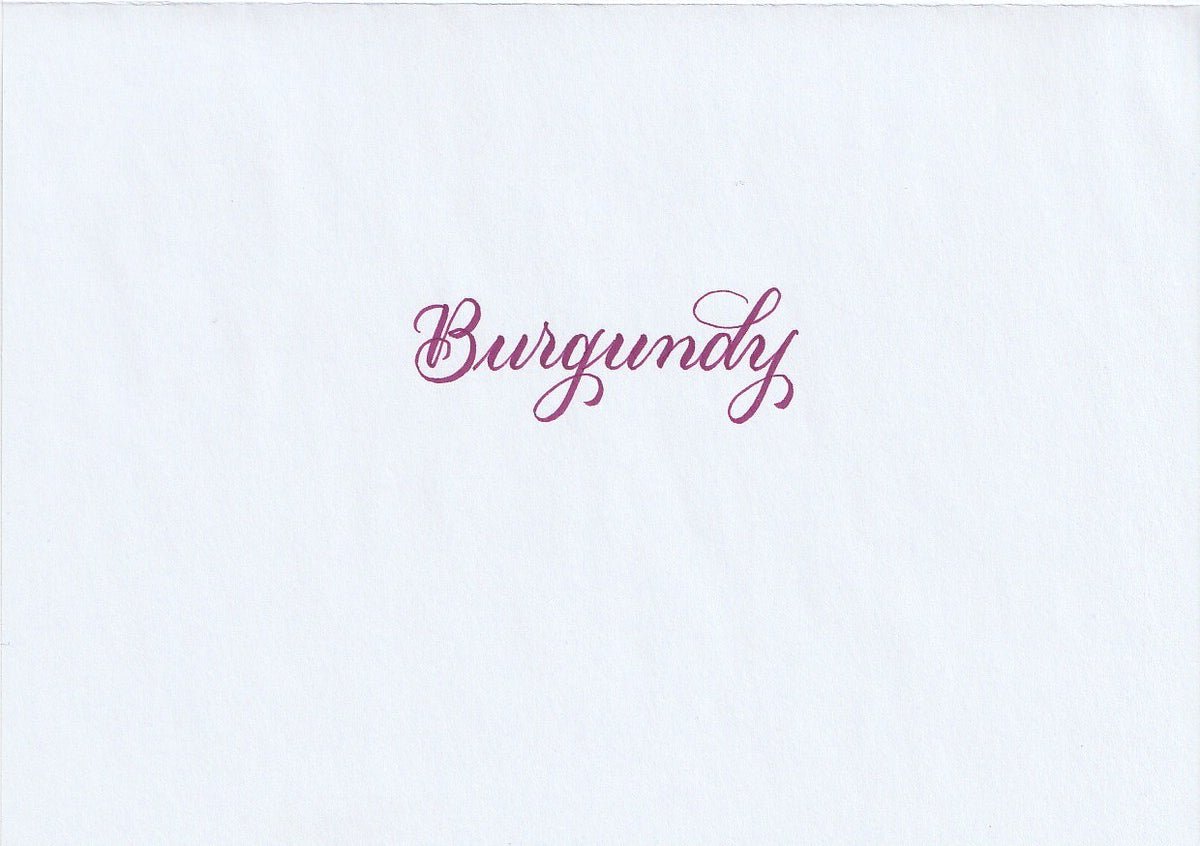 Handskriven text med ordet "Burgundy" i rödlila färg, skriven med Pentel Brush Sign Pen i färgen Burgundy.