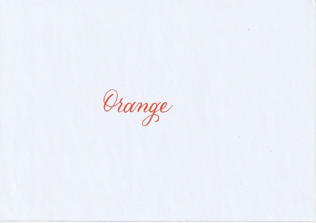 Handskriven text med ordet "Orange" i orange färg, skrivet med Pentel Brush Sign Pen i färgen Orange.