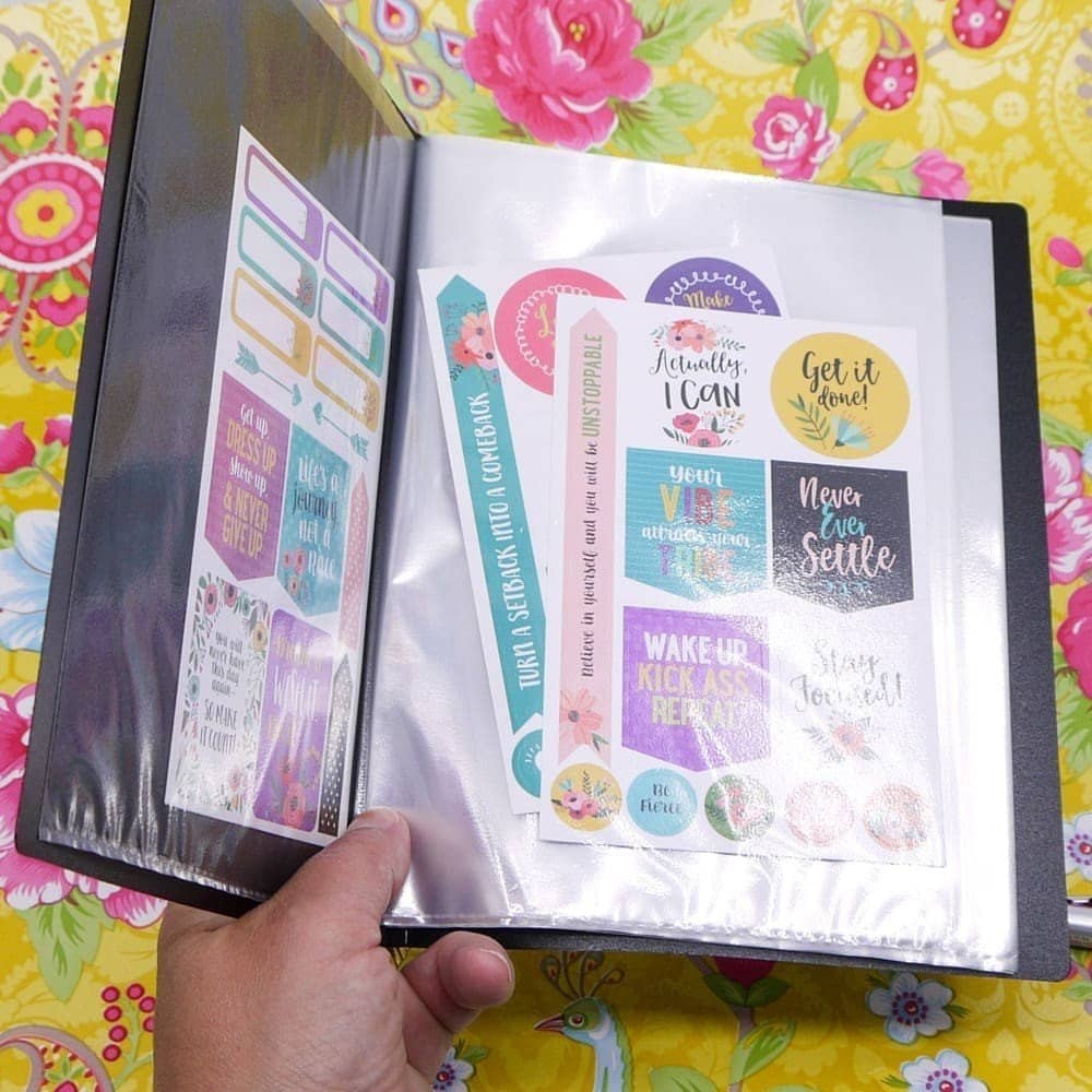 Svart förvaringsmapp med plastfickor är uppslagen. Klistermärken förvaras i denna mapp. Demopärm A5 Svart från Bantex