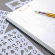 Dotted Journal Stencil Set 12 - pack från Peter Pauper Press - På bild används stencilerna i en anteckningsbok - Tidformera