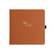 Orange kvadratisk anteckningsbok. Guldpräglat med fallande lönnlöv på pärmen
Dotted Notebook Swirling Leaves SQ -  - Archer & Olive - Tidformera