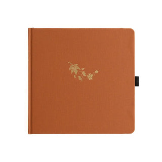 Orange kvadratisk anteckningsbok. Guldpräglat med fallande lönnlöv på pärmen
Dotted Notebook Swirling Leaves SQ -  - Archer & Olive - Tidformera