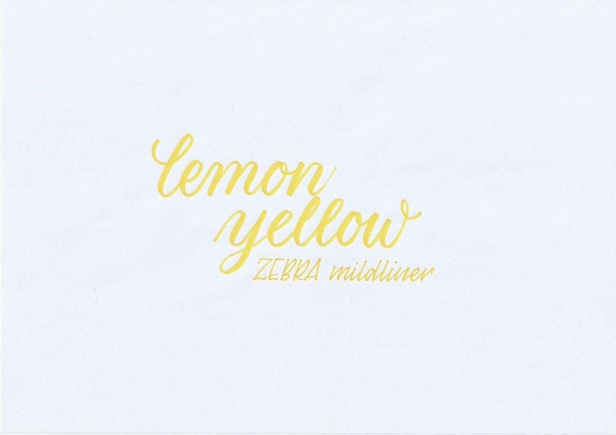 Handskriven text med orden "lemon yellow" och "ZEBRA mildliner" i citrongul färg, skriven med Zebra Mildliner Brush Pen i färgen Lemon Yellow.