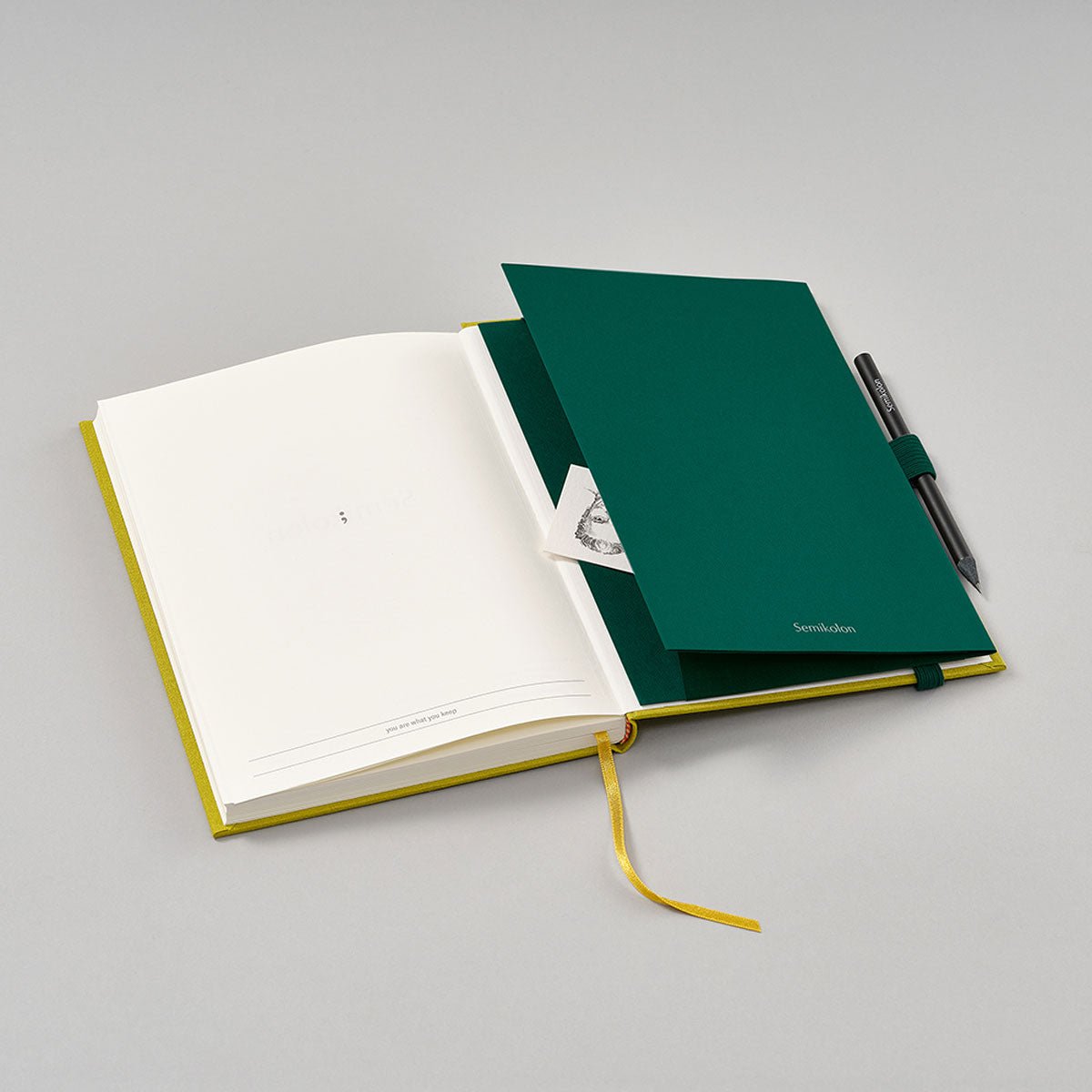 Patch Pocket - Forest från Semikolon. Mörkgrön självhäftande ficka med elastiskt pennhållare. - Tidformera