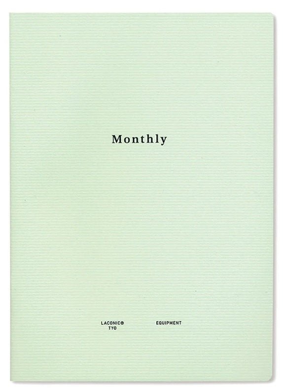 Skrivhäfte - Monthly från Laconic. Ett grönt skrivhäfte som det står Monthly på. Står även Laconic Equipment. Tidformera