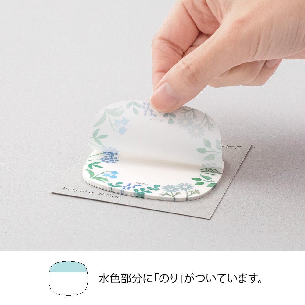Sticky Notes Transparency Wild Flowers från Midori. En hand drar upp en post-it lapp som har motiv med blommor - Tidformera