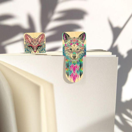 Wooden Booktags - Spirit animals från Cozywood. Två bokmärken sitter fäst i en bok. Ena bokmärke har en målad katt på och den andra är en målad varg. - Tidformera