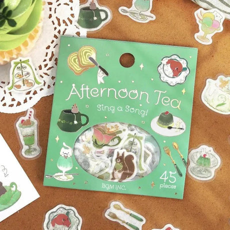 Flake stickers Afternoon Tea Party från BGM - Grön förpackning med klistermärken som ligger på ett bord. Runt ligger klistermärken med drinkar - Tidformera