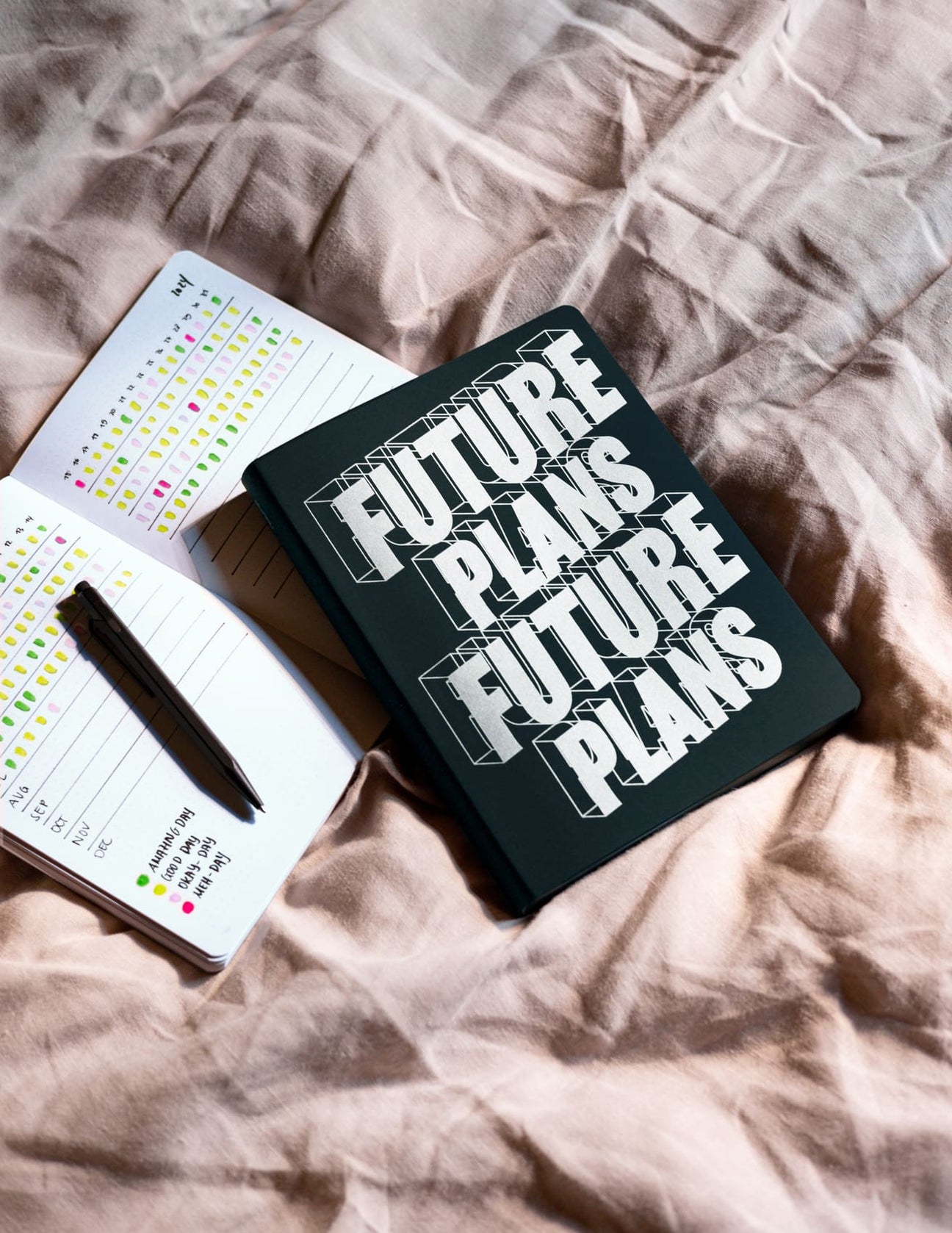 Nuuna Dotted notebook. Böcker som ligger på sängen. Ena har texten Future Plans på framsidan. - Tidformera