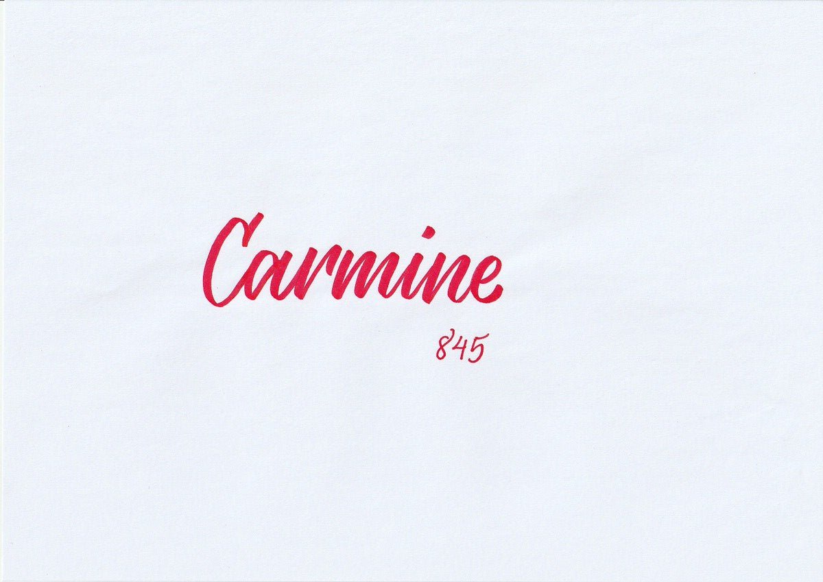 Handskriven text med ordet "Carmine" i karminröd färg, skriven med ABT Dual Brush Pen i nyansen 845 Carmine.