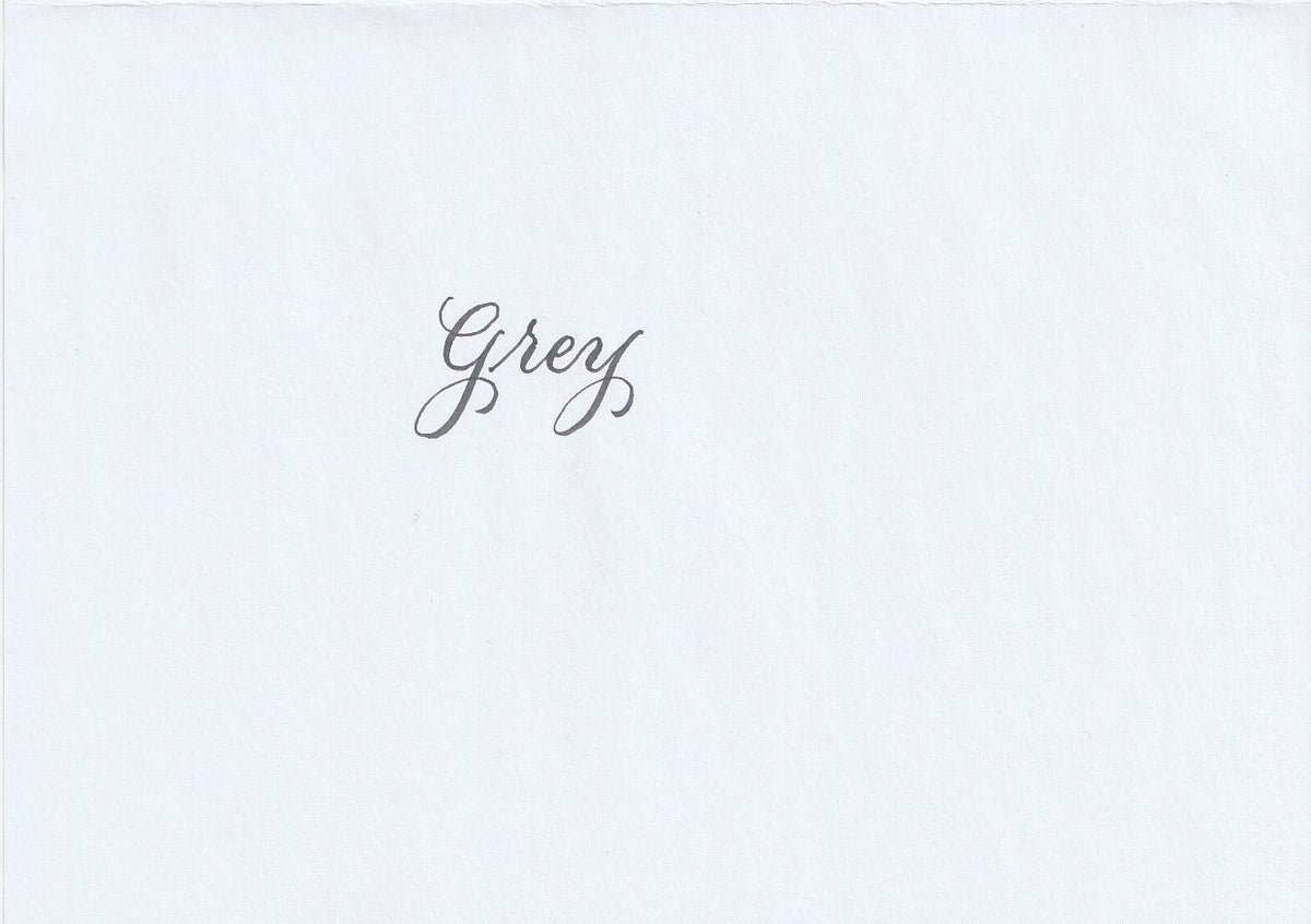 Handskriven text med ordet "Grey" i grå färg, skrivet med Pentel Brush Sign Pen i färgen Grey.