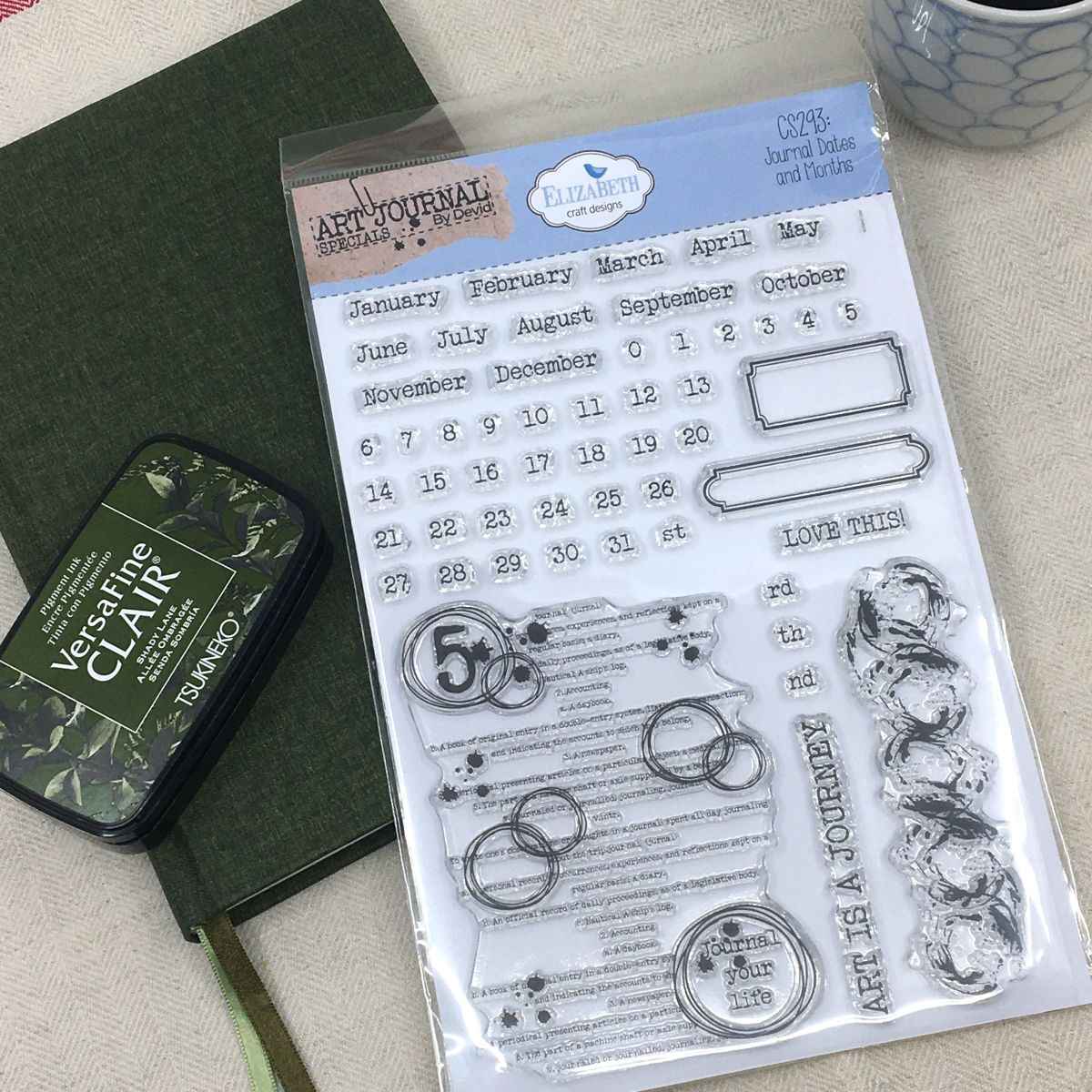 Clear stamps med tema Journal Dates and months ligger på en anteckningsbok och tillsammans med stämpeldyna.