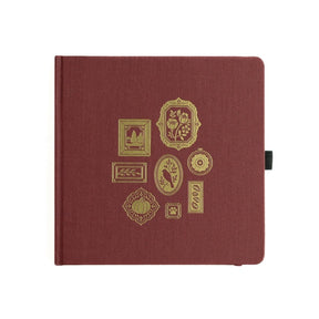 Kvadratiskt mörkröd prickad anteckningsbok. Motiv på pärmen är små guldfärgade tavlor
Dotted Notebook Frame Wall SQ - från Archer & Olive - Tidformera