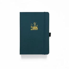 Grön anteckningsbok med en hög med böcker avbildade på pärmen. Dotted Notebook Stack of Books B5 från Archer & Olive.