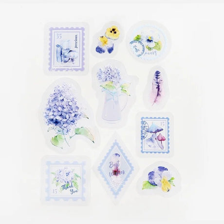 Flake stickers Clear Garden Post Office - Lavender från BGM. Klistermärken ligger utspridda med motiv med fjäder, penseer, hortensia och frimärken. - Tidformera